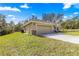 Side view of the home highlighting the two-car garage with stone accents and manicured lawn at 20396 Sw 79Th Lane, Dunnellon, FL 34431