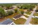 An aerial view of a home on a tree-lined street with a large driveway at 21 Pecan Pass Ter, Ocala, FL 34472