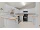 Functional kitchen with ample white cabinetry and black appliances at 21 Pecan Pass Ter, Ocala, FL 34472