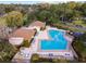 Aerial view of community pool, lake, and recreation center surrounded by lush trees at 2418 Se 17Th Cir, Ocala, FL 34471