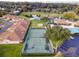 Aerial view of tennis courts surrounded by lush trees, lake, and community pool at 2418 Se 17Th Cir, Ocala, FL 34471