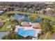 Aerial view of community pool, lake, and recreation center surrounded by lush trees at 2418 Se 17Th Cir, Ocala, FL 34471