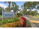 Community entrance sign surrounded by colorful landscaping and mature trees at 2418 Se 17Th Cir, Ocala, FL 34471