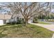 Charming home exterior with well-maintained lawn, mature trees and beautiful landscaping along the driveway at 2418 Se 17Th Cir, Ocala, FL 34471