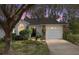 Charming single-story home at dusk, featuring a well-manicured lawn, mature tree, and an attached one car garage at 2418 Se 17Th Cir, Ocala, FL 34471