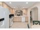 Bright kitchen featuring white appliances, light wood cabinets, and arched pass-through to living area at 2418 Se 17Th Cir, Ocala, FL 34471