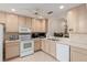 Bright kitchen featuring light wood cabinets, white appliances, and a view into another room at 2418 Se 17Th Cir, Ocala, FL 34471