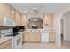 Bright kitchen featuring tile floors, light wood cabinets, white appliances, and a pass-through window at 2418 Se 17Th Cir, Ocala, FL 34471