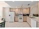 Bright kitchen with light wood cabinets, white appliances, and neutral countertops provides a functional cooking space at 2418 Se 17Th Cir, Ocala, FL 34471