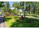 Picturesque street view featuring a community entrance with lush landscaping, mature trees, and a glimpse of the lake at 2418 Se 17Th Cir, Ocala, FL 34471