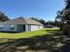 Well-maintained backyard showcasing a covered lanai, lush lawn, and mature trees at 243 Marion Oaks Trl, Ocala, FL 34473