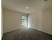 Bright bedroom with plush carpet, neutral walls, and a window providing natural light at 243 Marion Oaks Trl, Ocala, FL 34473