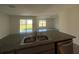 Kitchen island featuring a double sink and granite counter, leading to the open living space at 243 Marion Oaks Trl, Ocala, FL 34473