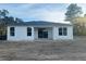 Rear view of the property showcasing the patio area, large windows, and a well-designed exterior at 2728 Sw 154Th Pl, Ocala, FL 34473