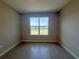 Bright bedroom featuring a window with a view of the neighborhood and wood-look tile flooring at 2728 Sw 154Th Place Rd, Ocala, FL 34473