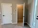 Hallway with doors to a closet and other rooms, featuring light gray walls and wood-look tile flooring at 2728 Sw 154Th Place Rd, Ocala, FL 34473