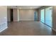 Spacious living room with wood-look tile flooring, light gray walls, and sliding glass doors at 2728 Sw 154Th Place Rd, Ocala, FL 34473
