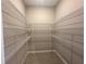 Walk-in closet with white wire shelving and wood-look tile flooring, providing ample storage space at 2728 Sw 154Th Place Rd, Ocala, FL 34473