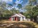 Charming home with a covered front porch and a metal roof, surrounded by trees at 3081 Ne 49Th St, Ocala, FL 34479