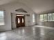 View of the living room featuring tile floors, large windows, and a vaulted ceiling at 3081 Ne 49Th St, Ocala, FL 34479