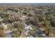 Wide aerial view of the house with gray roof and sheds surrounded by a densely wooded neighborhood at 3204 Ne 16Th Ave, Ocala, FL 34479