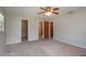 Spacious bedroom with carpet flooring, three closets, and a ceiling fan at 3204 Ne 16Th Ave, Ocala, FL 34479