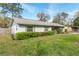 Gray single story home with a well-maintained lawn, colorful flower bushes, and a partially fenced yard at 3204 Ne 16Th Ave, Ocala, FL 34479