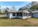 Rear exterior of home with a screened porch and manicured lawn at 3204 Ne 16Th Ave, Ocala, FL 34479