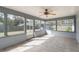 Enclosed porch with tile floor, fan, and multiple windows showcasing the outdoor landscape at 3204 Ne 16Th Ave, Ocala, FL 34479