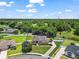 Aerial view of a beautifully landscaped home featuring a well-manicured front yard and surrounded by lush green trees at 3401 Se 49Th Ave, Ocala, FL 34480