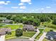 Aerial view of a beautifully landscaped home featuring a well-manicured front yard and surrounded by lush green trees at 3401 Se 49Th Ave, Ocala, FL 34480