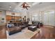 Expansive living room merging with a modern kitchen, featuring dark wood floors and a cozy leather sectional at 3401 Se 49Th Ave, Ocala, FL 34480