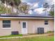 Exterior back view of home featuring solar panels, windows, and access door at 3832 Se 2Nd St, Ocala, FL 34471