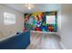 A quirky bedroom features painted murals, wood-look floors, and a ceiling fan at 3832 Se 2Nd St, Ocala, FL 34471