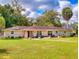 Charming single-story home featuring a well-manicured lawn and inviting front porch with chairs at 3832 Se 2Nd St, Ocala, FL 34471