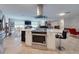 Open concept kitchen with stone wall, island range, stainless steel vent hood, and tiled floors at 3832 Se 2Nd St, Ocala, FL 34471