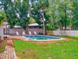 Backyard features a refreshing pool surrounded by lush greenery and a brick patio at 3832 Se 2Nd St, Ocala, FL 34471