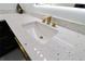 Close up of a bathroom sink featuring white countertop with black speckles and gold hardware at 4534 Se 13Th St, Ocala, FL 34471