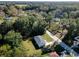 An aerial view of a charming single-Gathering home with a well-maintained lawn and a long driveway surrounded by lush trees at 480 Nw 55Th Ave, Ocala, FL 34482