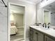 Bathroom featuring a gray vanity, marble floors, a large mirror, and access to a bedroom at 480 Nw 55Th Ave, Ocala, FL 34482