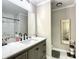 Modern bathroom with white marble floors, grey cabinets, and a framed mirror at 480 Nw 55Th Ave, Ocala, FL 34482