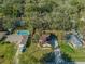 An aerial view showcases the house, pool, the green lawn, mature trees, and surrounding treed neighborhood at 5115 Se 20Th St, Ocala, FL 34480