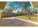 Fenced backyard featuring a patio, green grass, and mature trees, perfect for outdoor enjoyment at 5115 Se 20Th St, Ocala, FL 34480