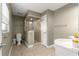 Well-lit bathroom featuring a glass-door shower, a toilet, and neutral tile flooring at 5115 Se 20Th St, Ocala, FL 34480