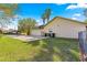 Side exterior featuring a garage, manicured lawn and tall palm trees at 5115 Se 20Th St, Ocala, FL 34480