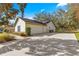 A home showcasing a spacious driveway leading to a two-car garage and lush landscaping at 5115 Se 20Th St, Ocala, FL 34480