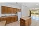 Kitchen featuring wood cabinets, an island, and an open layout to the living area at 5464 Sw 41St St, Ocala, FL 34474