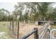 Fenced enclosure, set within a backdrop of trees, provides a secure area for outdoor activities at 5490 Se Highway 42, Summerfield, FL 34491