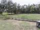 A large, fenced backyard on a grassy lot with mature trees in the background at 5490 Se Highway 42, Summerfield, FL 34491