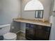 Bathroom featuring vanity with granite counters, dark wood cabinets, and toilet at 5490 Se Highway 42, Summerfield, FL 34491